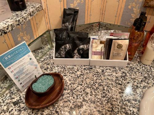 a bathroom counter with a bowl of soap and other products at Hotel Grand Garden (Adult Only) in Yokohama