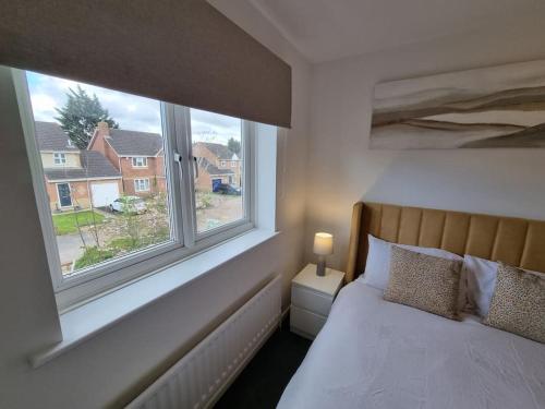 a bedroom with a bed and two windows at Charming 3Bed House in Strood in Wainscot