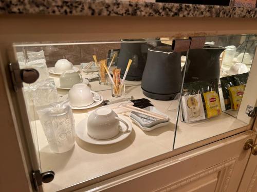 a counter with cups and saucers on it at Hotel Grand Garden (Adult Only) in Yokohama