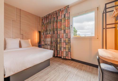 ソースハイムにあるB&B HOTEL Mulhouse Sausheimのベッドと窓が備わるホテルルーム