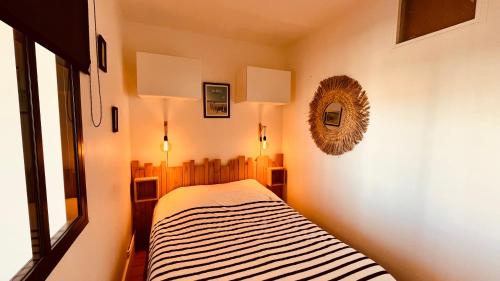 une chambre avec un lit et un miroir au mur dans l'établissement Le Richelieu, charme face ocean, à Saint-Jean-de-Monts