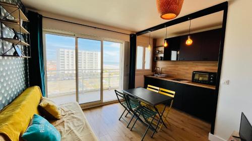 un salon avec un canapé jaune et une table dans l'établissement Le Richelieu, charme face ocean, à Saint-Jean-de-Monts