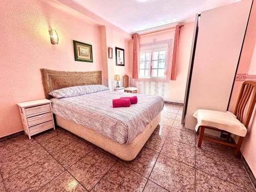 ein Schlafzimmer mit einem Bett mit zwei roten Kissen darauf in der Unterkunft Centrico Apartamento Rincon de la Victoria , cerca de la Playa in Rincón de la Victoria