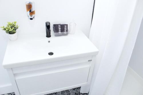 une salle de bain avec un lavabo blanc et une douche dans l'établissement Cozy Stylish Apartment near Newark, NJ Airport, à Elizabeth