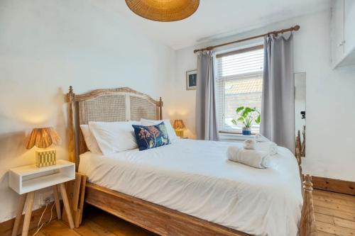a bedroom with a large white bed with a window at Stylish 2BD with Private Garden and Sauna in Oxford