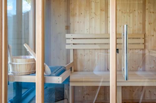 a sauna with a wooden wall and a bucket at Stylish 2BD with Private Garden and Sauna in Oxford