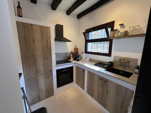 a kitchen with wooden cabinets and a sink and a window at Casa Nova, Moraira in Moraira