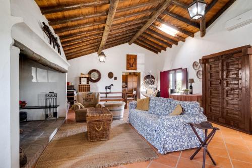a living room with a blue couch and a wooden ceiling at Alandroal Nature & Pool Retreat- Courela dos Tojos in Alandroal