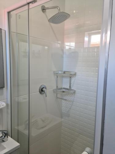 a bathroom with a glass shower with a toilet at Suidersee Block 2, Hartenbos in Hartenbos