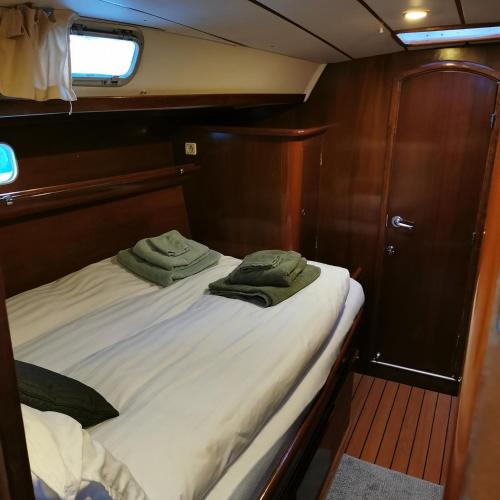 ein Bett auf einem Boot mit zwei grünen Handtüchern drauf in der Unterkunft Weekend liveaboard sailing tour in Harstad