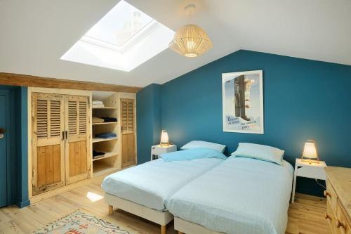 1 Schlafzimmer mit blauen Wänden und 1 Bett mit 2 Kissen in der Unterkunft Magnifique Villa, idéal famille Ste Foy Les Lyon in Sainte-Foy-lès-Lyon