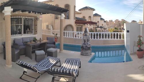 un patio con 2 sillas, una mesa y una piscina en Casa Sortino Rizzo en San Miguel de Salinas
