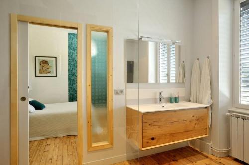 ein Bad mit einem Waschbecken, einem Spiegel und einem Bett in der Unterkunft Magnifique Villa, idéal famille Ste Foy Les Lyon in Sainte-Foy-lès-Lyon