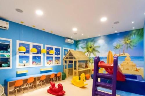 a childs room with a blue wall with a beach and a bunk bed at Flat em resort - pé na areia, Camboinhas in Niterói