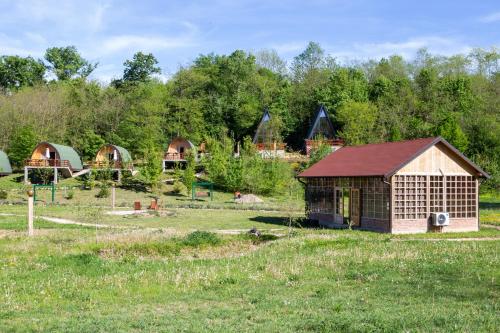 a group of huts in a field with grass at Imanje Lotus Garden in Šabac