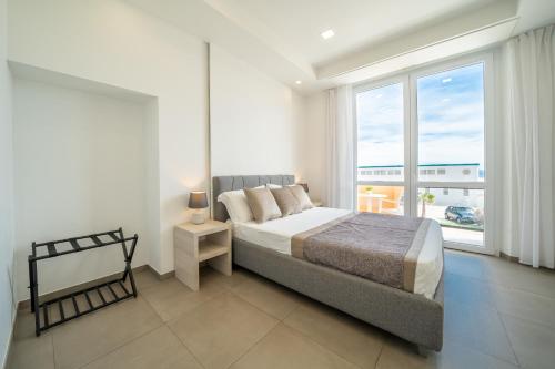 a bedroom with a bed and a large window at Poseidon Rooms in Cagliari