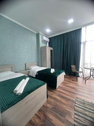 a hotel room with two beds and a table at Hotel Saba in Rustavi