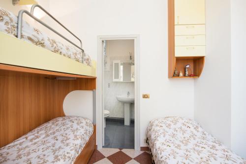 two beds in a small room with a bathroom at MARNE IV - Cosy 2 pièces en plein centre de Menton in Menton
