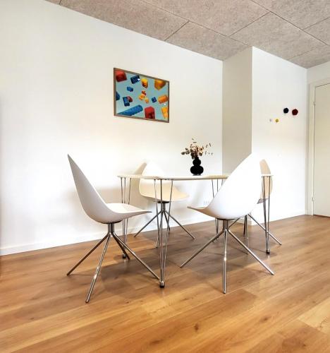 a dining room with white chairs and a table at Lego Fans Аpartment #1 in Billund Center in Billund