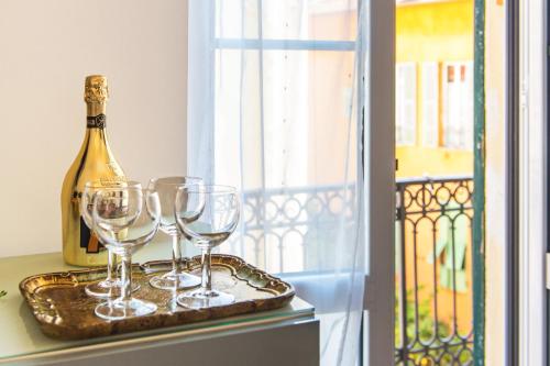 - un plateau avec des verres à vin et une bouteille à la fenêtre dans l'établissement MARNE IV - Cosy 2 pièces en plein centre de Menton, à Menton