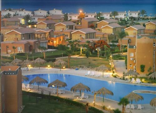 a large swimming pool with umbrellas and a resort at jenylyn`s chalet` families only` in Ain Sokhna