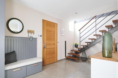 - un couloir avec une porte en bois et des escaliers dans l'établissement La maison Lùmen, à Montagnac