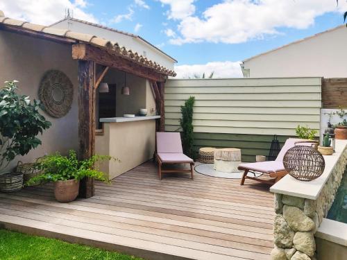 une terrasse en bois avec deux chaises et un kiosque dans l'établissement La maison Lùmen, à Montagnac