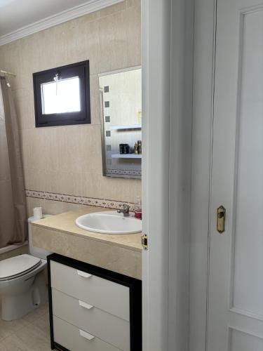 a bathroom with a sink and a toilet and a mirror at Villa Palmeras in Costa Teguise