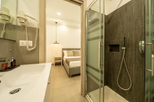 a bathroom with a bath tub and a bedroom at Poseidon Rooms in Cagliari