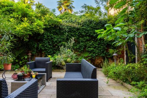 a patio with chairs and tables in a garden at Hotel Il Mercante di Venezia in Venice