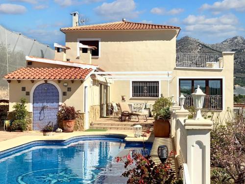 ein Haus mit einem Pool vor einem Haus in der Unterkunft 4 bedrooms villa with sea view private pool and furnished terrace at Callosa de Ensarria 9 km away from the beach in Callosa d'en Sarrià