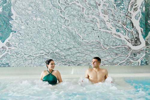 a man and a woman sitting in a bath tub at Stic Urban Hotel & SPA in San Antonio
