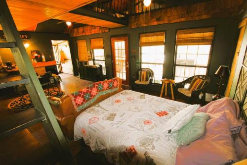 1 dormitorio con 1 cama en una habitación con ventanas en Hyde Hollow Cabin, en Eureka Springs