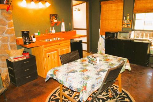 una cocina con mesa y una cocina con fregadero en Hyde Hollow Cabin, en Eureka Springs