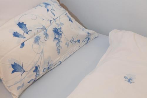 a pillow on a bed with blue flowers on it at Apartment Babenhausen in Babenhausen