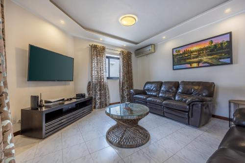 a living room with a couch and a flat screen tv at 3BR Mediterranean Oasis Retreat in San Giljan, Malta in St Julian's