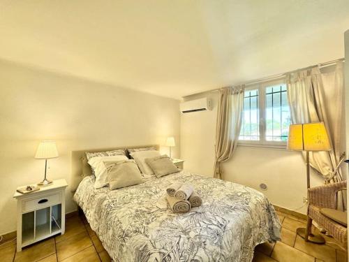 une chambre avec un lit avec deux chapeaux dessus dans l'établissement Bas de villa provençale 2 pièces avec Jardin, à Villeneuve-Loubet