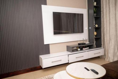 a living room with a tv and a white table at 203 Marina Bay Luxury Apartments Suite, Umhlanga in Durban