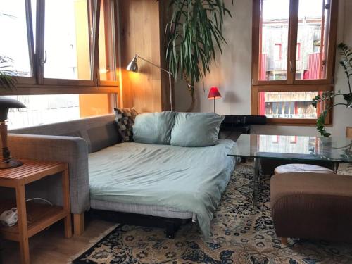 un salon avec un canapé et une table en verre dans l'établissement Olympic Village - Sunny Dupleix, à LʼÎle-Saint-Denis