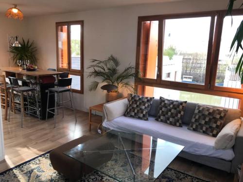 un salon avec un canapé et une table dans l'établissement Olympic Village - Sunny Dupleix, à LʼÎle-Saint-Denis