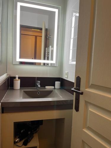 une salle de bain avec un lavabo et un miroir dans l'établissement Superbe appartement une chambre vue mer piscine tennis, à Cannes
