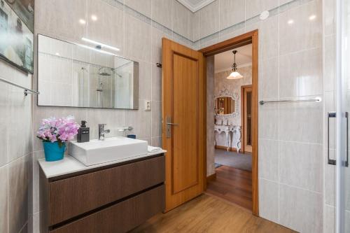 a bathroom with a sink and a mirror at Viravento - Family House in Espinho