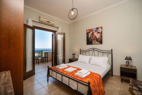 a bedroom with a bed with a view of the ocean at Leyenia Serenity Houses in Kókkinon Khoríon