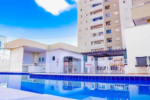 um hotel com piscina em frente a um edifício em Um plus na sua acomodação - LOFT FELAU em Cuiabá