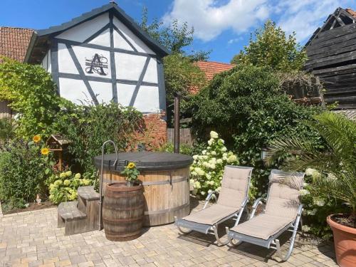 a backyard with a gazebo and two chairs and a barrel at Altes Grabenhöfchen in Nordheim vor der Rhön