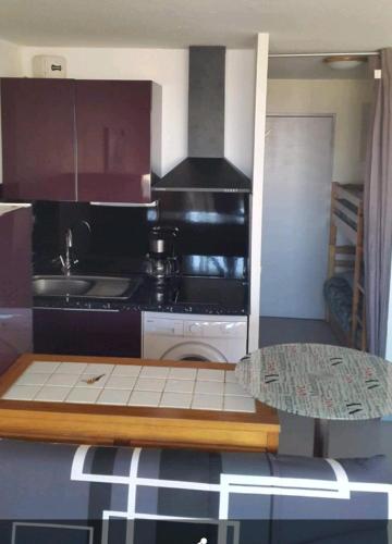Il comprend une petite cuisine équipée d'une cuisinière et d'une table. dans l'établissement Studio climatise vue mer avec piscine, à Canet