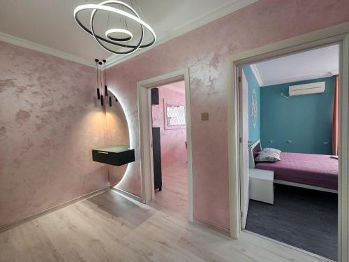a room with a bedroom with a bed and a chandelier at Апартамент Елинор in Pomorie