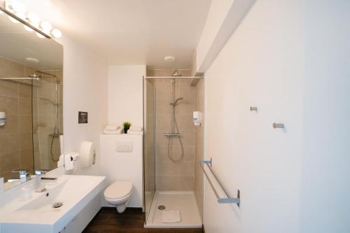 a bathroom with a shower and a sink and a toilet at Hotel Ambassadeur in Ostend