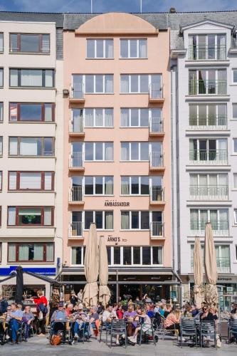 a group of people sitting in chairs in front of a building at Hotel Ambassadeur in Ostend