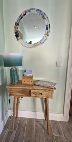 a wooden table with a mirror on a wall at Gleann Ciuin in Ballymartin